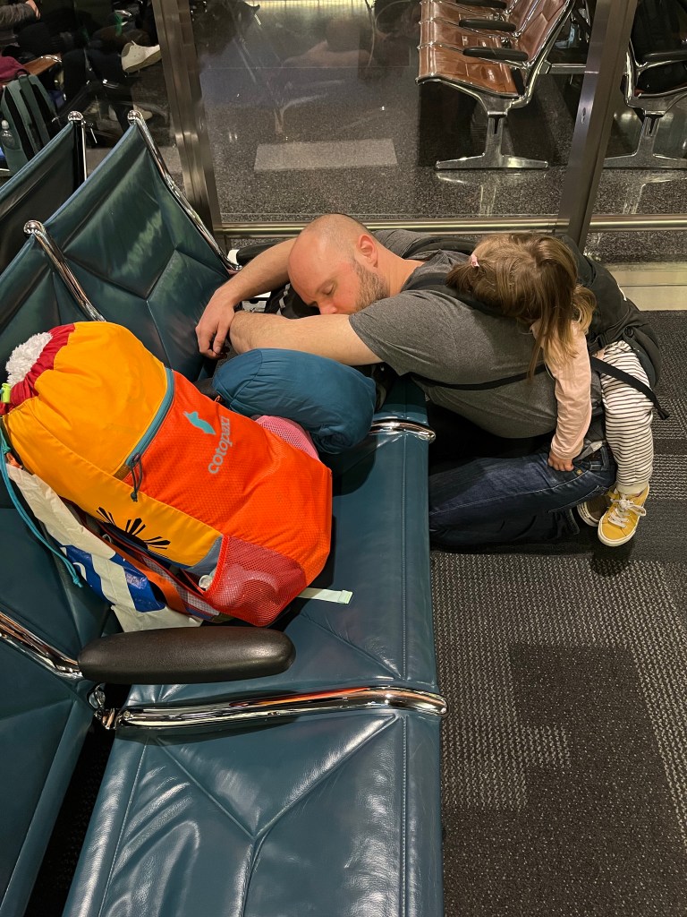John and Tilly sleeping in Doha airport